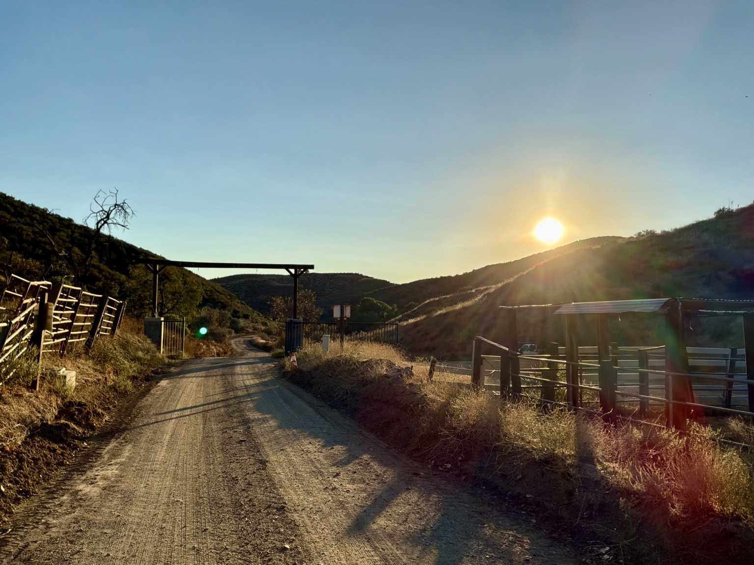Sunset over the entrance road and gates at the Angel Trust ranch